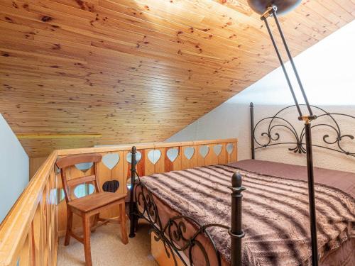 una camera da letto con un letto e un soffitto in legno di Appartement Rénové 3 Pièces Mezzanine à 50m des Pistes, Balcon, Lave-Linge et Casier à Skis - FR-1-356-206 a Valmorel