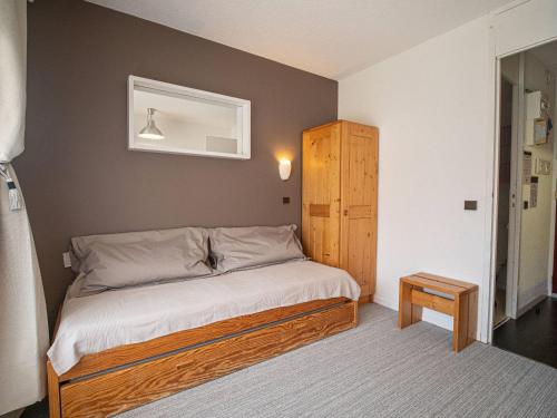 une chambre avec un lit et une armoire en bois dans l'établissement Studio lumineux avec accès direct aux pistes et à l'ESF - FR-1-356-233, à Valmorel
