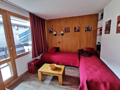- une chambre avec un lit rouge et une table dans l'établissement Studio charmant au cœur du Laitelet, pieds des pistes, commerces à proximité - FR-1-355-69, à Méribel