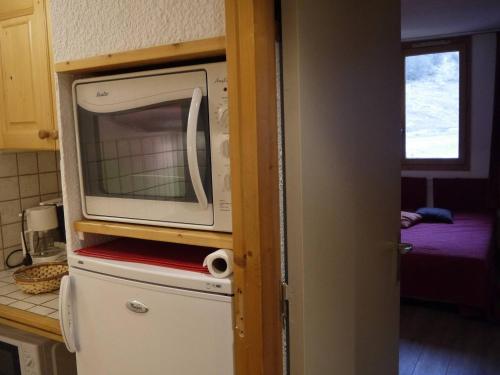 un micro-ondes au-dessus d'un réfrigérateur dans une cuisine dans l'établissement Studio charmant au cœur du Laitelet, pieds des pistes, commerces à proximité - FR-1-355-69, à Méribel