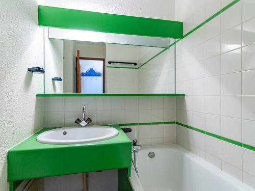 La salle de bains verte est pourvue d'un lavabo et d'une baignoire. dans l'établissement Appartement à Méribel Mottaret - Pied des pistes, balcon, casier à skis - FR-1-355-88, à Méribel