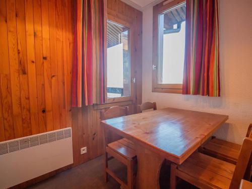 - une salle à manger avec une table en bois et 2 fenêtres dans l'établissement Studio skis aux pieds à Valmorel, proche ESF et commerces, animaux acceptés - FR-1-356-180, à Valmorel