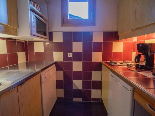 - une cuisine avec du carrelage coloré sur le mur dans l'établissement Valmorel - Appartement 2 pièces - 4 pers - Pieds des pistes - FR-1-356-203, à Valmorel