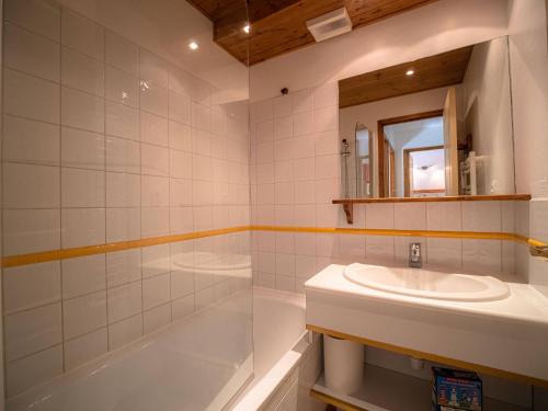 une salle de bain avec un lavabo, une baignoire et un miroir dans l'établissement Studio divisible, proche pistes et commerces, terrasse sud - FR-1-356-237, à Valmorel