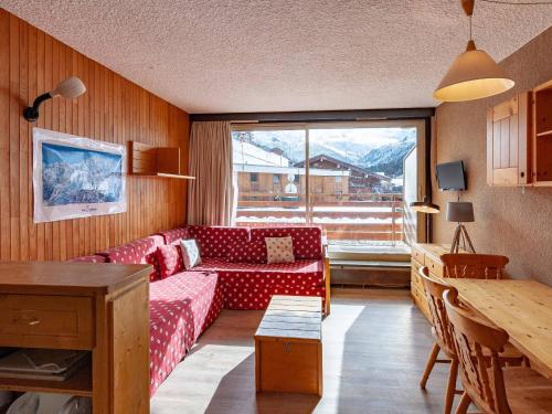 - un salon avec un canapé rouge et une fenêtre dans l'établissement Agréable appartement, proche des pistes, balcon, casier à skis - FR-1-355-23, à Méribel
