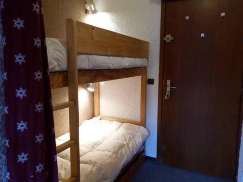 Ce lit superposé se trouve dans un dortoir doté d'une porte. dans l'établissement Agréable appartement, proche des pistes, balcon, casier à skis - FR-1-355-23, à Méribel