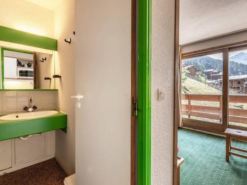 La salle de bains est pourvue d'un lavabo vert et d'une fenêtre. dans l'établissement Appartement confortable, pieds des pistes, balcon, casier à skis - FR-1-355-58, à Méribel