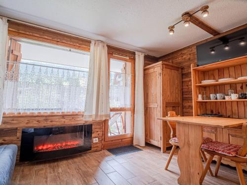 - un salon avec une cheminée devant une fenêtre dans l'établissement Studio chaleureux et rénové avec terrasse, proche des pistes - Planchamp, Valmorel - FR-1-356-379, à Valmorel