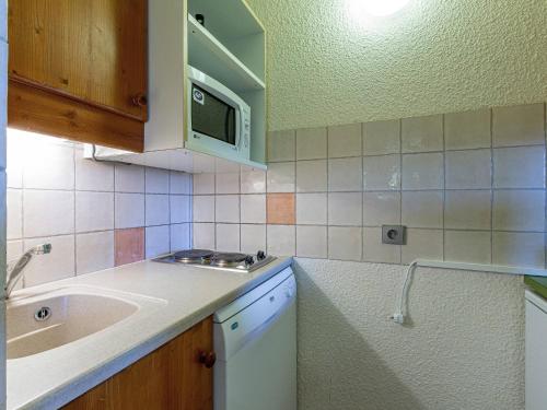 une cuisine avec un évier et un micro-ondes dans l'établissement Studio divisible pour 4 pers à Valmorel proche pistes, commerces et remontées - FR-1-356-364, à Valmorel