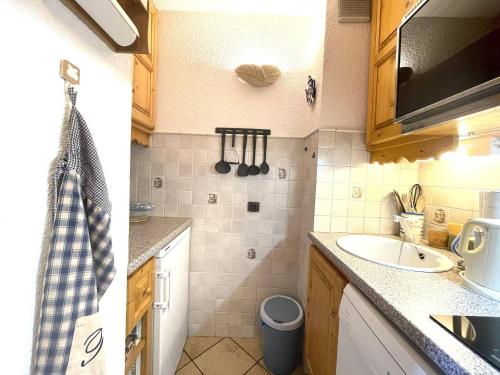- une petite cuisine avec un évier et un miroir dans l'établissement Studio Divisible, Proche Pistes et Commerces, Tout Confort – Valmorel, Crève Coeur - FR-1-356-393, à Valmorel