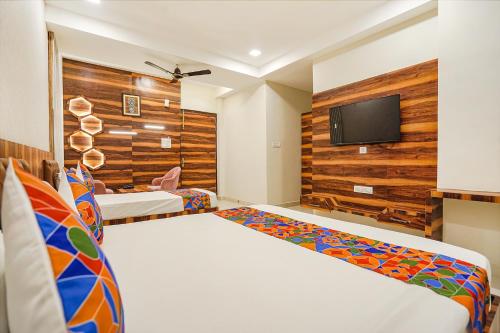 a bedroom with two beds and a flat screen tv at FabHotel TS Inn in Faithfulganj