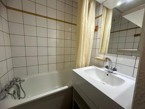 une salle de bain avec un lavabo et une baignoire dans l'établissement Studio Divisible Fonctionnel · Accès Direct Pistes · Balcon · 4 Pers - FR-1-181-2242, à La Plagne Tarentaise