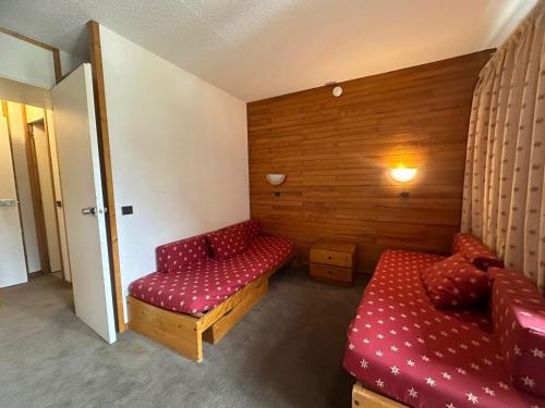 une chambre avec un canapé rouge et un banc rouge dans l'établissement Studio Divisible Fonctionnel · Accès Direct Pistes · Balcon · 4 Pers - FR-1-181-2242, à La Plagne Tarentaise