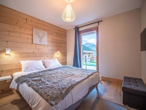 a bedroom with a large bed and a window at Chalet 3* Valmorel, skis aux pieds, 3 chambres, parking, WIFI - FR-1-356-401 in Valmorel