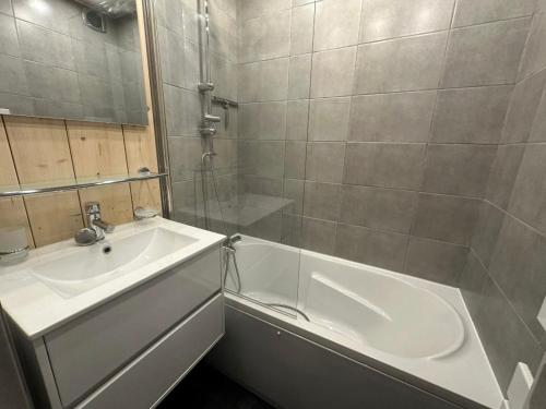 une salle de bain avec une baignoire blanche et un lavabo dans l'établissement Studio lumineux proche des pistes avec balcon - Animaux admis - FR-1-181-2368, à La Plagne Tarentaise