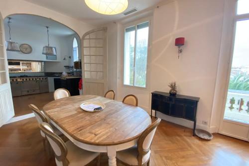 une salle à manger avec une table et des chaises en bois dans l'établissement 06BI - Beautiful apartment with garden and terrace, au Cannet