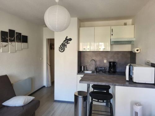 une cuisine avec un comptoir et des tabourets dans une pièce dans l'établissement Appartement rénové proche plage avec terrasse et parking privé - FR-1-782-24, au Barcarès