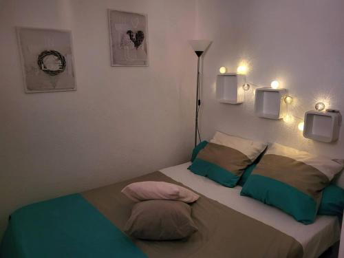 - une chambre dotée d'un lit avec deux oreillers et des lumières dans l'établissement Appartement rénové proche plage avec terrasse et parking privé - FR-1-782-24, au Barcarès