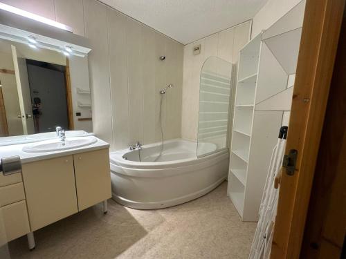 une salle de bain blanche avec une baignoire et un lavabo dans l'établissement Appartement 2P 5pers au pied des pistes à Plagne Bellecôte - FR-1-181-2727, à La Plagne Tarentaise
