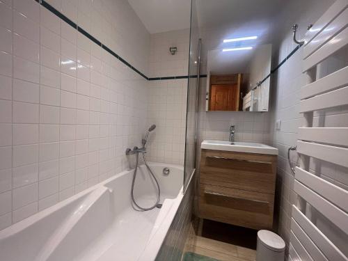 une salle de bain avec une baignoire, un lavabo et une douche dans l'établissement Appartement cosy près des pistes avec kitchenette équipée - FR-1-355-246, à Les Allues