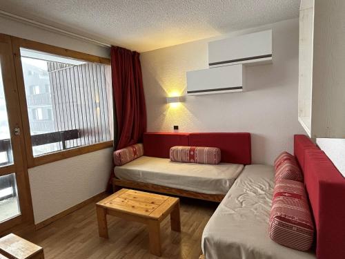 Cette petite chambre comprend un canapé et une table. dans l'établissement Appartement divisible, rénové, au pied des pistes avec cuisine équipée - FR-1-355-253, à Les Allues