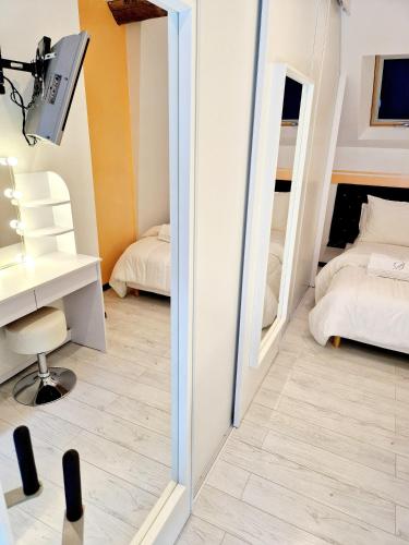 a mirror in a room with two beds at Maison cosy piscine jacuzzi sauna in Épervans