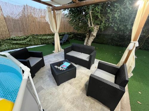 a patio with chairs and a couch and a table at L’angolo rosa in Carosino