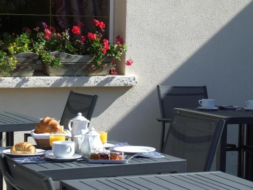 una mesa al aire libre con desayuno en Hôtel de la Poste, en Chagny