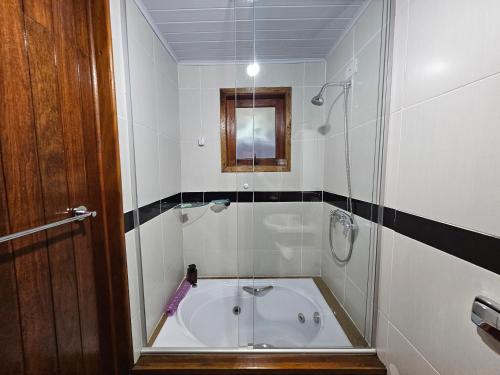 a small bathroom with a shower and a bath tub at A Cabana in Campos do Jordão