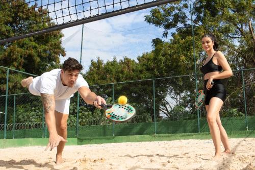 a man and a woman playing a game of tennis at Sumaré Park Hotel in Sumaré