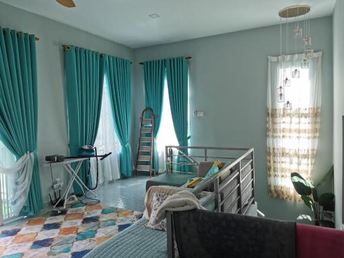 a bedroom with blue walls and a bed with a chair at Teratak Dusun NadzYan in Bukit Selambau