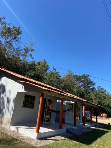 a small white building with orange poles on it at Praia do Jatobá in Sao Jorge