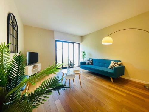 een woonkamer met een blauwe bank en een tafel bij Casa du Haras in Angers