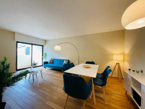 een woonkamer met een tafel en een blauwe bank bij Casa du Haras in Angers