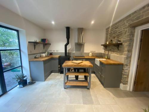 a kitchen with a table and a stone wall at The Potting Shed in Glastonbury