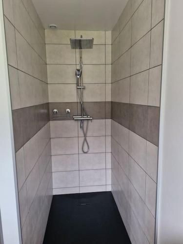 La salle de bains est pourvue d'une douche et d'un sol noir. dans l'établissement Magnifique appartement Jonquille, à Xonrupt-Longemer