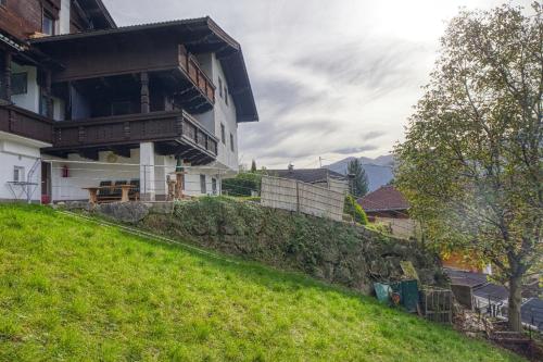 a house on a grassy hill with a building at Apart Sunnseitn Sonnwend in Bruck am Ziller