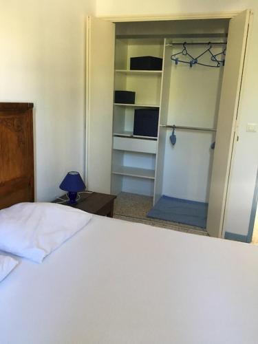 une chambre avec un lit blanc et un placard dans l'établissement Villa Provence proche du Mont Ventoux avec piscine et jardin, à Caromb