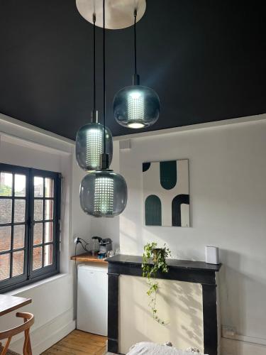 une cuisine avec trois lumières suspendues au plafond dans l'établissement L'Oasis Confort, Centre-Ville, à Arras