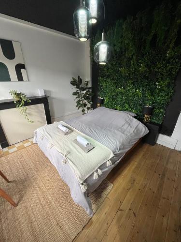 - un lit dans une chambre avec une plante dans l'établissement L'Oasis Confort, Centre-Ville, à Arras