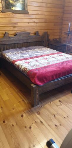 a bed in a room with a wooden floor at wooden villa in Mardakan