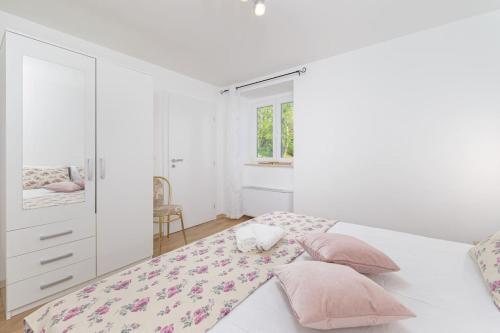 a white bedroom with a large bed with pink pillows at Villa Dobrila by IstriaLux in Stari Pazin