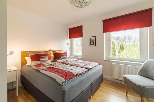 a bedroom with a bed and a chair and a window at Apartment Premium Plus im Gustav Seitz Gästehaus in Trebnitz