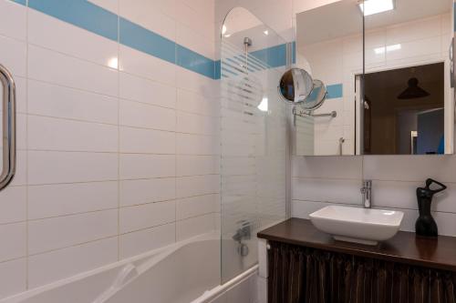 a bathroom with a sink and a tub and a mirror at Upton 2 - Arradon Golfe du Morbihan in Arradon