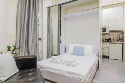 une chambre avec un lit blanc et une chaise dans l'établissement Charming studio - 2P - Jardin du Luxembourg, à Paris