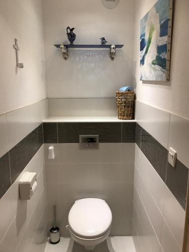 La salle de bains est pourvue de toilettes blanches et d'une étagère. dans l'établissement Gîte de standing climatisé avec piscine, à Sainte-Cécile-les-Vignes