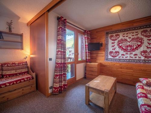 - une chambre avec un lit et une fenêtre avec un tapis dans l'établissement Studio cosy à 80m des remontées et 100m des commerces à Valmorel - FR-1-356-198, à Valmorel