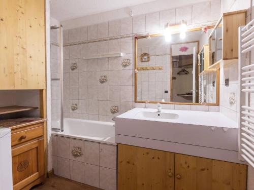 une salle de bain avec une baignoire, un lavabo et un miroir dans l'établissement Appartement 2 Pièces, 4 Pers. à Valmorel - Proche Pistes et Commerces, Terrasse et Parking Inclus - FR-1-356-264, à Valmorel