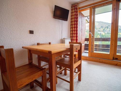 - une table et des chaises en bois dans une chambre avec fenêtre dans l'établissement Studio cabine au pied des pistes avec animaux acceptés à Valmorel - FR-1-356-304, à Valmorel