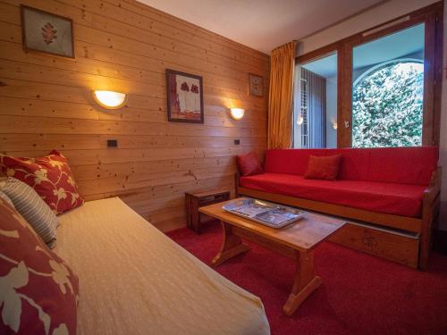 un salon avec un canapé rouge et une table dans l'établissement Appartement cosy, 100m des pistes, balcon, casier à skis, quartier calme, proche commerces - FR-1-356-327, à Valmorel